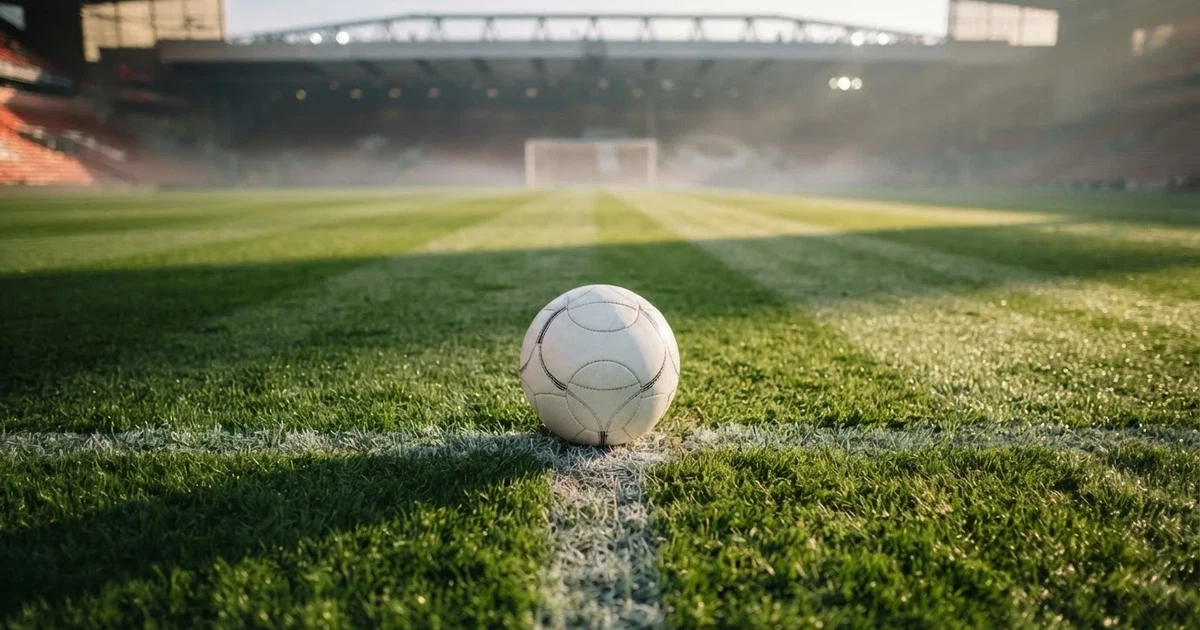 Un balón en el punto central de un campo de césped a la luz de la mañana