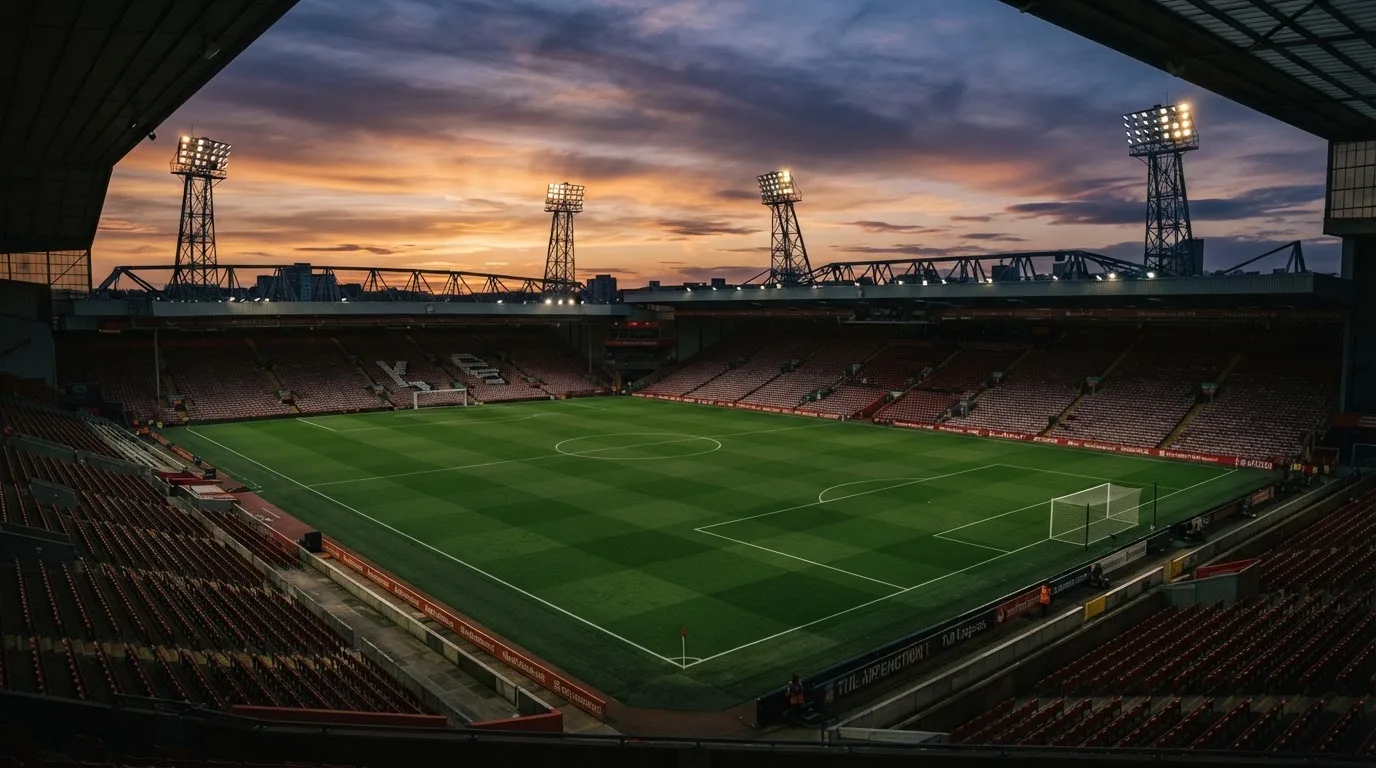 Un estadio de fútbol vacío con torres de iluminación al atardecer